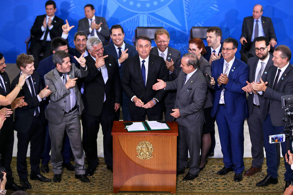 O presidente Jair Bolsonaro assina decreto para facilitar o acesso a armas em cerimônia no Palácio do Planalto, em maio de 2019