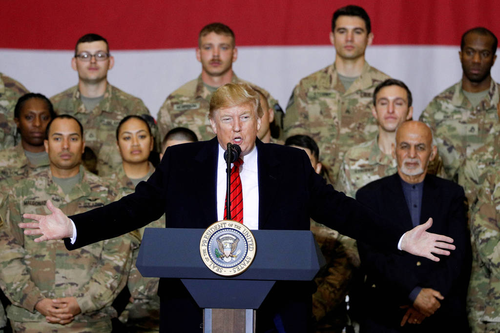 Donald Trump discursa ao lado de soldados e do presidente afegão Asraf Ghani (de preto), durante visita à base Bagram, em novembro de 2019