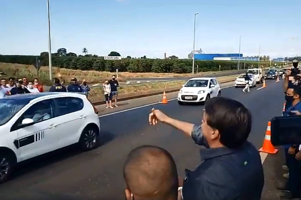 Presidente Jair Bolsonaro acena para simpatizantes em Araguari (MG) Presidente Jair Bolsonaro acena para simpatizantes em Araguari (MG)