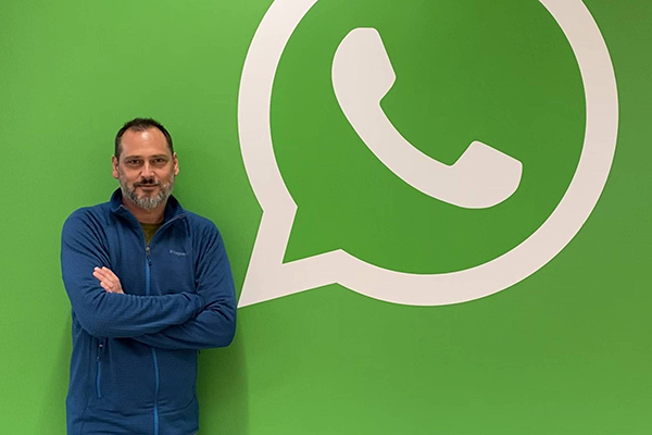 Pablo Bello, diretor de Políticas Públicas do WhatsApp para a América Latina, posa na frente de logotipo da empresa