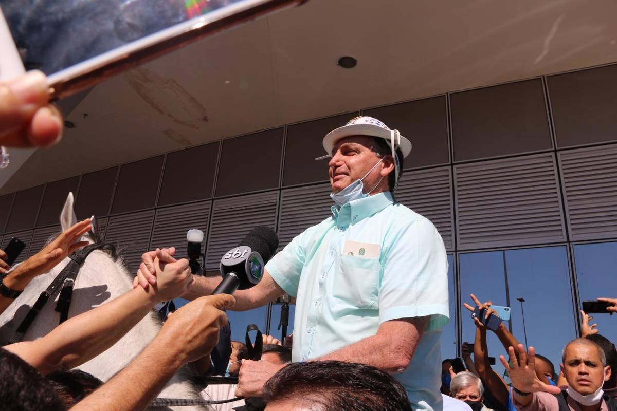 O presidente Jair Bolsonaro usa chapéu e monta um animal enquanto é recepcionado por apoiadores na chegada à cidade de São Raimundo Nonato (PI) 