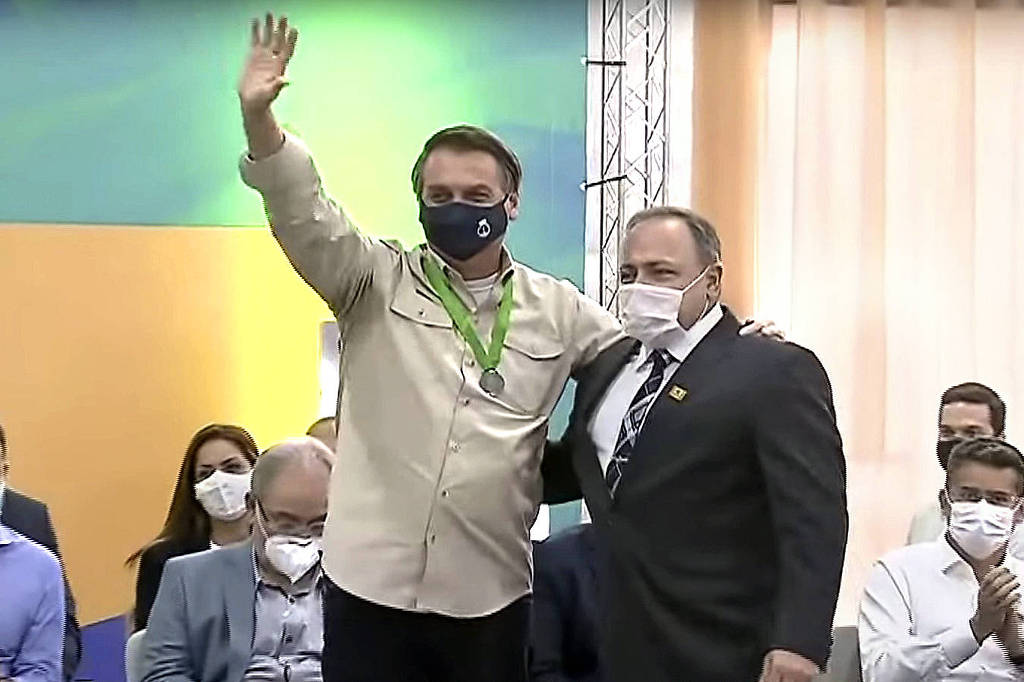O presidente Jair Bolsonaro acena ao lado do ex-ministro Eduardo Pazuello (Saúde) durante evento em Manaus