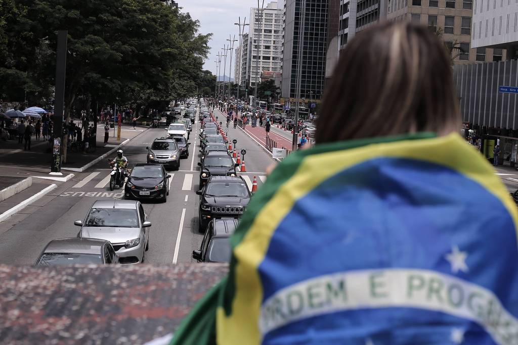 Manifestante observa carreata na avenida Paulista, no centro de São Paulo, em ato pelo impeachment promovido por MBL e Vem Pra Rua Manifestante observa carreata na avenida Paulista, no centro de São Paulo, em ato pelo impeachment promovido por MBL e Vem Pra Rua