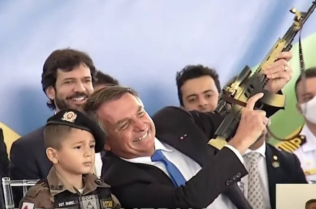 O presidente Jair Bolsonaro com uma criança vestida com farda da Polícia Militar mineira