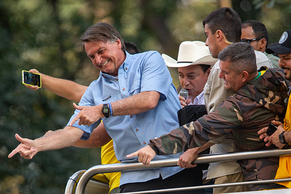 O presidente Jair Bolsonaro ao lado de apoiadores em cima de um carro de som na avenida Paulista, em São Paulo