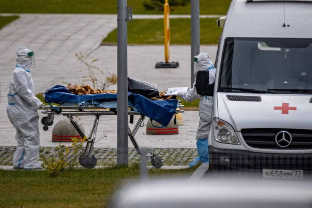 Profissionais de saúde carregam paciente com Covid em hospital próximo a Moscou