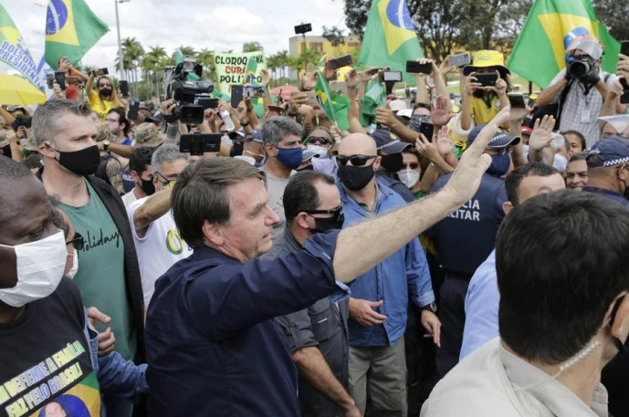 Sem máscara, o presidente Jair Bolsonaro cumprimenta simpatizantes na frente do Palácio do Planalto