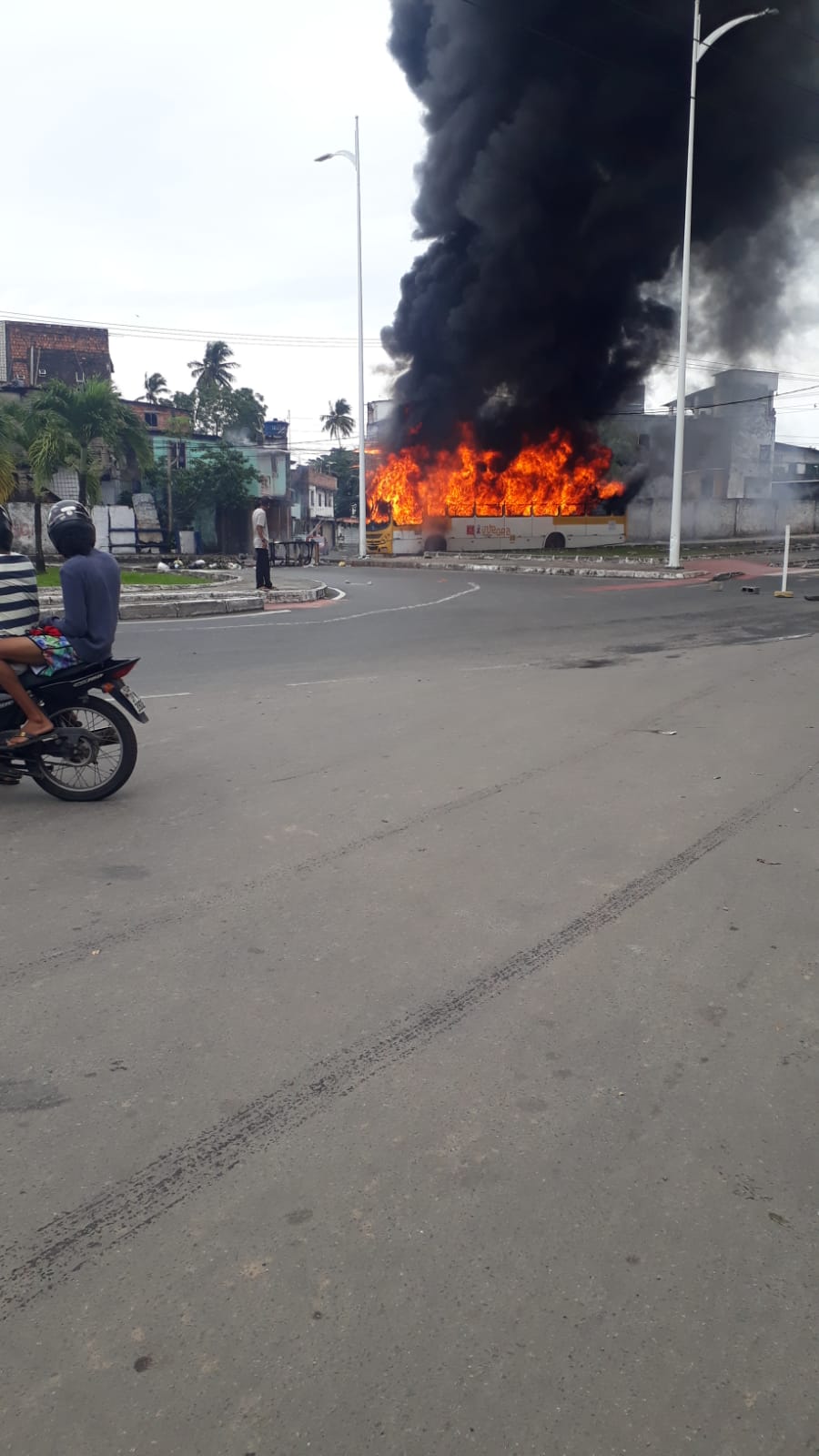 Manifestantes que incendiaram um ônibus no início da tarde deste domingo (14)
