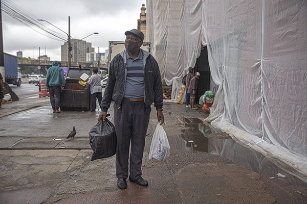 Vagner Benedito, 67, mostra alimentos que pegou pouco antes do descarte 
