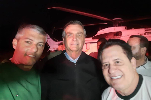 O presidente Jair Bolsonaro com o prefeito de Buriti Alegre, André Chaves, e o cantor Marrone 