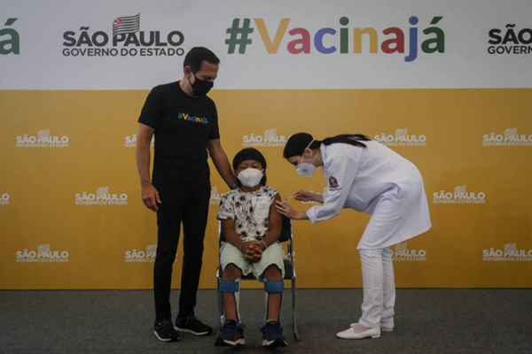 Davi Seremrámiwe Xavante é vacinado no Hospital das Clínicas, em São Paulo, ao lado do governador João Doria (PSDB)