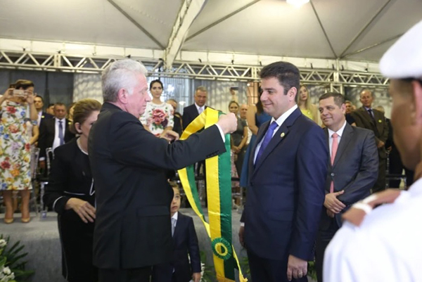Pai do governador, Eládio Cameli, entrega a faixa ao filho, na solenidade de posse em 1º de janeiro de 2019