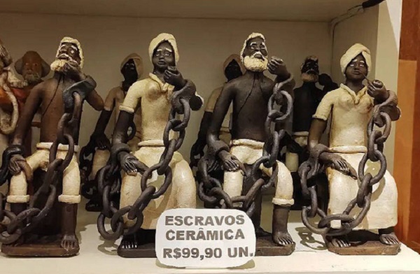 Suvenires de cerâmica com imagens de pessoas negras representadas como escravos acorrentados eram vendidos em loja no aeroporto de Salvador Suvenires de cerâmica com imagens de pessoas negras representadas como escravos acorrentados eram vendidos em loja no aeroporto de Salvador