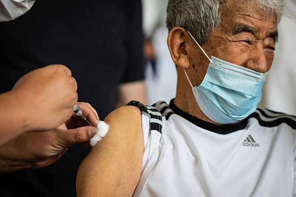 Idoso toma vacina contra a Covid-19