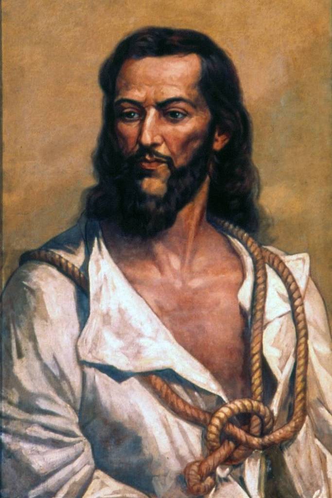 Retrato de Tiradentes. Na imagem, um homem branco de barba e cabelos longos, pretos, olha fixamente para o lado
