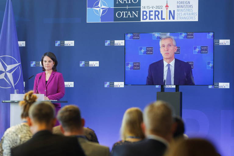 Jens Stoltenberg fala por videoconferência na conferência da Otan, em Berlim; no palco, a ministra do Exterior alemã, Annalena Baerbock