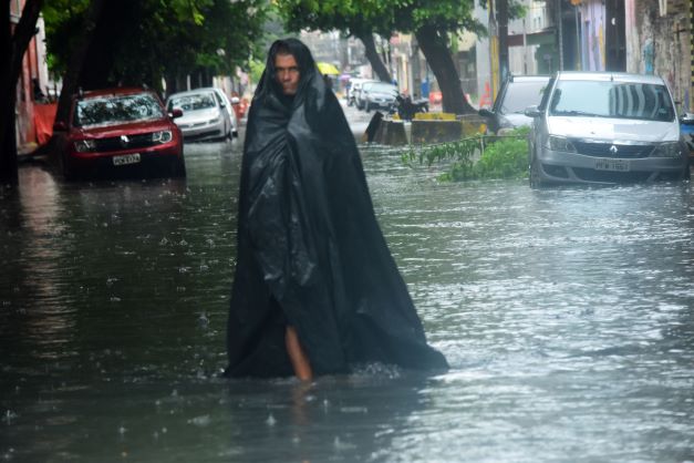 Homem caminha por rua alagada no Recife Homem caminha por rua alagada no Recife