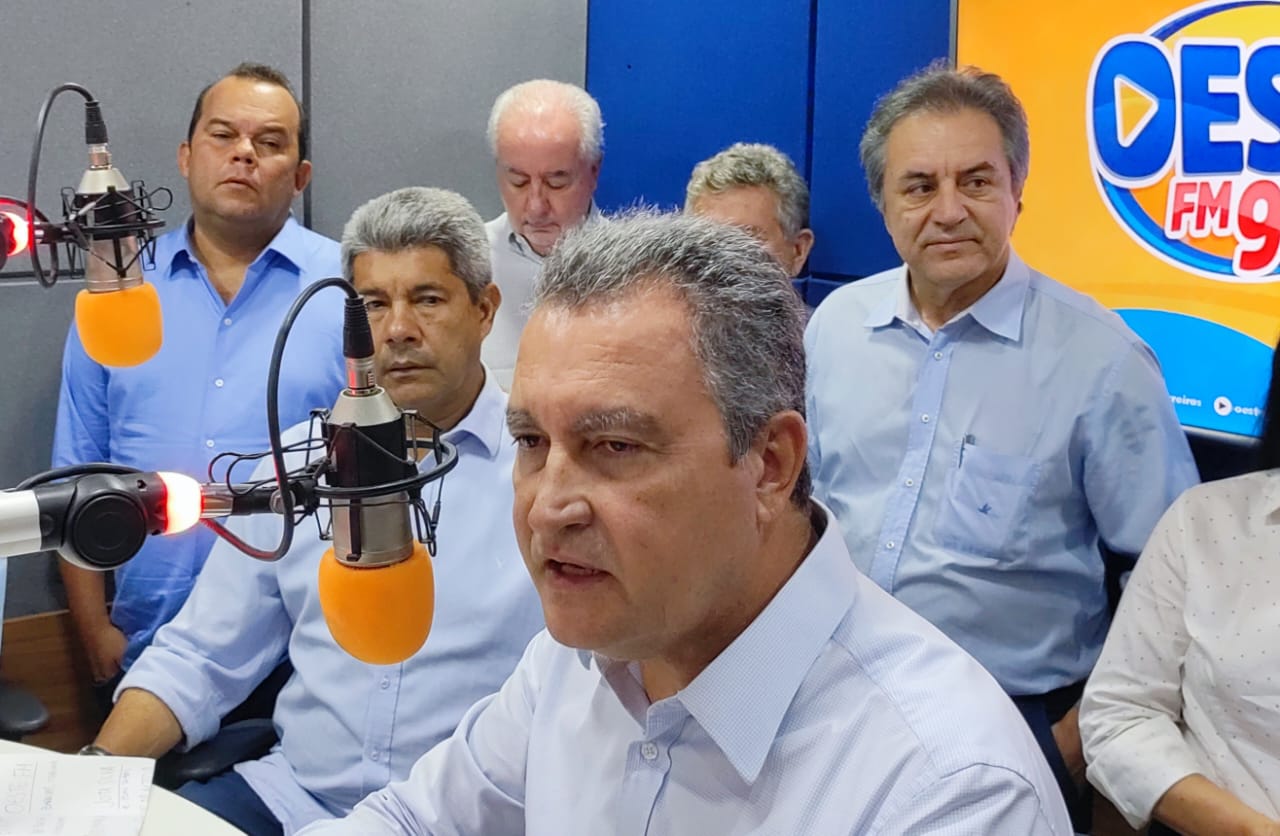 Rui Costa fala à Rádio Oeste FM, ao lado de Jerônimo Rodrigues e Geraldo Jr
