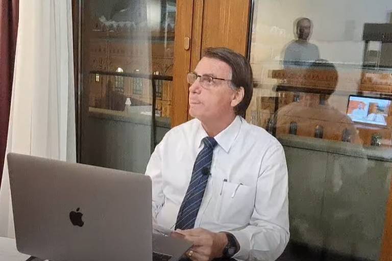 Bolsonaro escuta o filho Carlos Bolsonaro durante entrevista dada, da Rússia, ao programa Pingo nos I's, da Jovem Pan Bolsonaro escuta o filho Carlos Bolsonaro durante entrevista dada, da Rússia, ao programa Pingo nos I's, da Jovem Pan