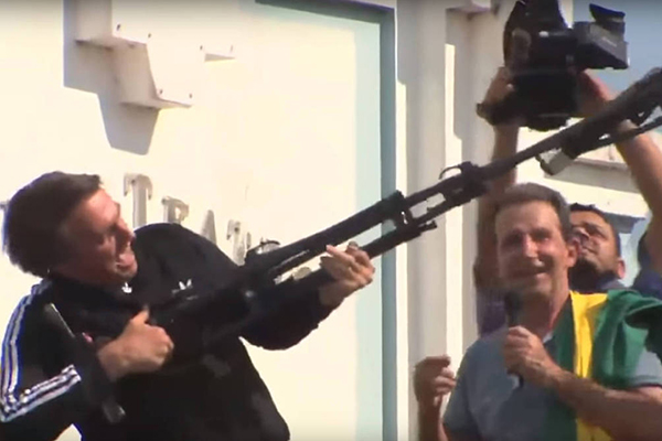 Bolsonaro usa um tripé simulando uma metralhadora em evento da campanha de 2018
