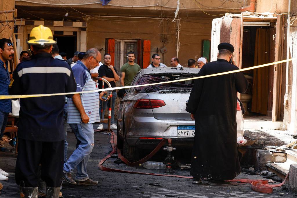 Padre copta do lado de fora da igreja de Abu Sifin, em Gizé, depois que ao menos 41 pessoas morreram durante um incêndio