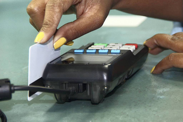 Pessoa passa cartão de crédito em máquina