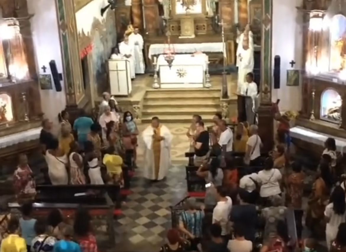 O padre Lázaro Muniz foi filmado puxando um coro de fiéis e balançando todo o recinto "ao negro toque do agogô"