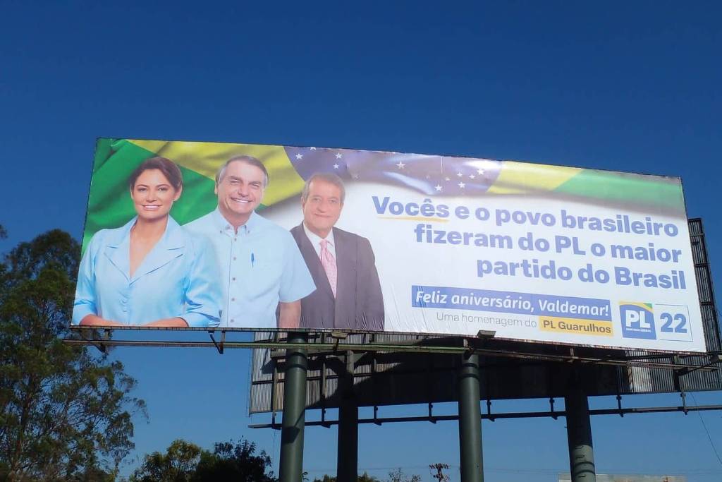 Outdoor com Michelle Bolsonaro, Jair Bolsonaro e Valdemar da Costa Neto às margens da via Dutra, em Guarulhos Outdoor com Michelle Bolsonaro, Jair Bolsonaro e Valdemar da Costa Neto às margens da via Dutra, em Guarulhos