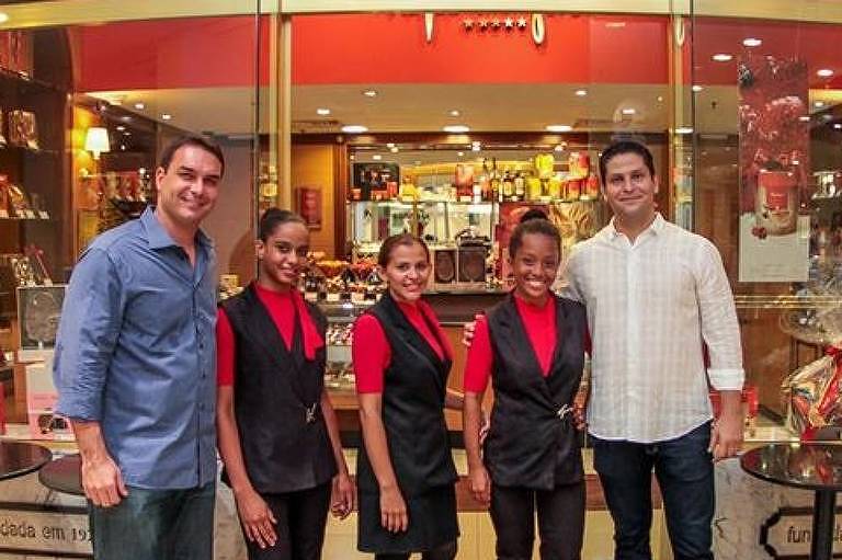 À esquerda, Flávio Bolsonaro e, à direita, seu ex-sócio Alexandre Santini, junto com funcionárias no dia da inauguração da loja de chocolate, no Rio de Janeiro À esquerda, Flávio Bolsonaro e, à direita, seu ex-sócio Alexandre Santini, junto com funcionárias no dia da inauguração da loja de chocolate, no Rio de Janeiro