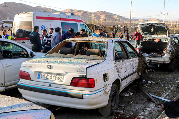 Pessoas entre carros atingidos em kerman por ataque durante homenagem ao general Qassim Suleimani, morto pelos EUA em 2020