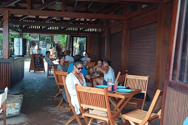 Mesas do restaurante Maré em frente à porta da Colônia de Pescadores de Praia do Forte