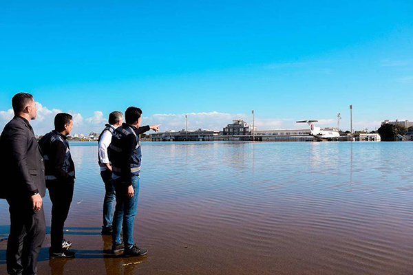 Comitiva do governo federal e da Anac obervam avião no meio da inundação, que ainda continua no aeroporto Salgado Filho, em Porto Alegre (R5)