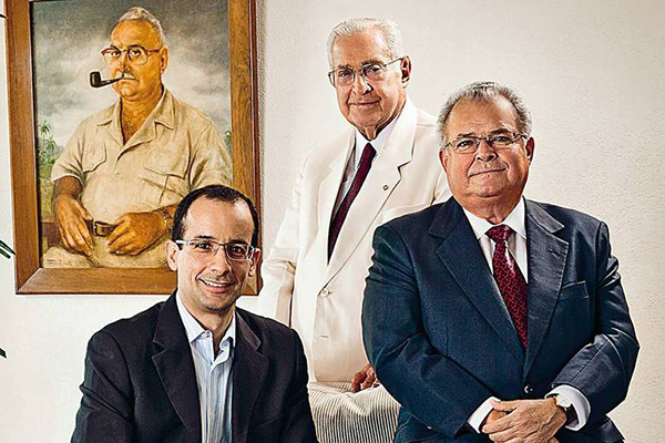 O empresário Marcelo Odebrecht com o pai, Emílio (de terno escuro), e o avô Norberto (ao fundo), na década de 1990 O empresário Marcelo Odebrecht com o pai, Emílio (de terno escuro), e o avô Norberto (ao fundo), na década de 1990