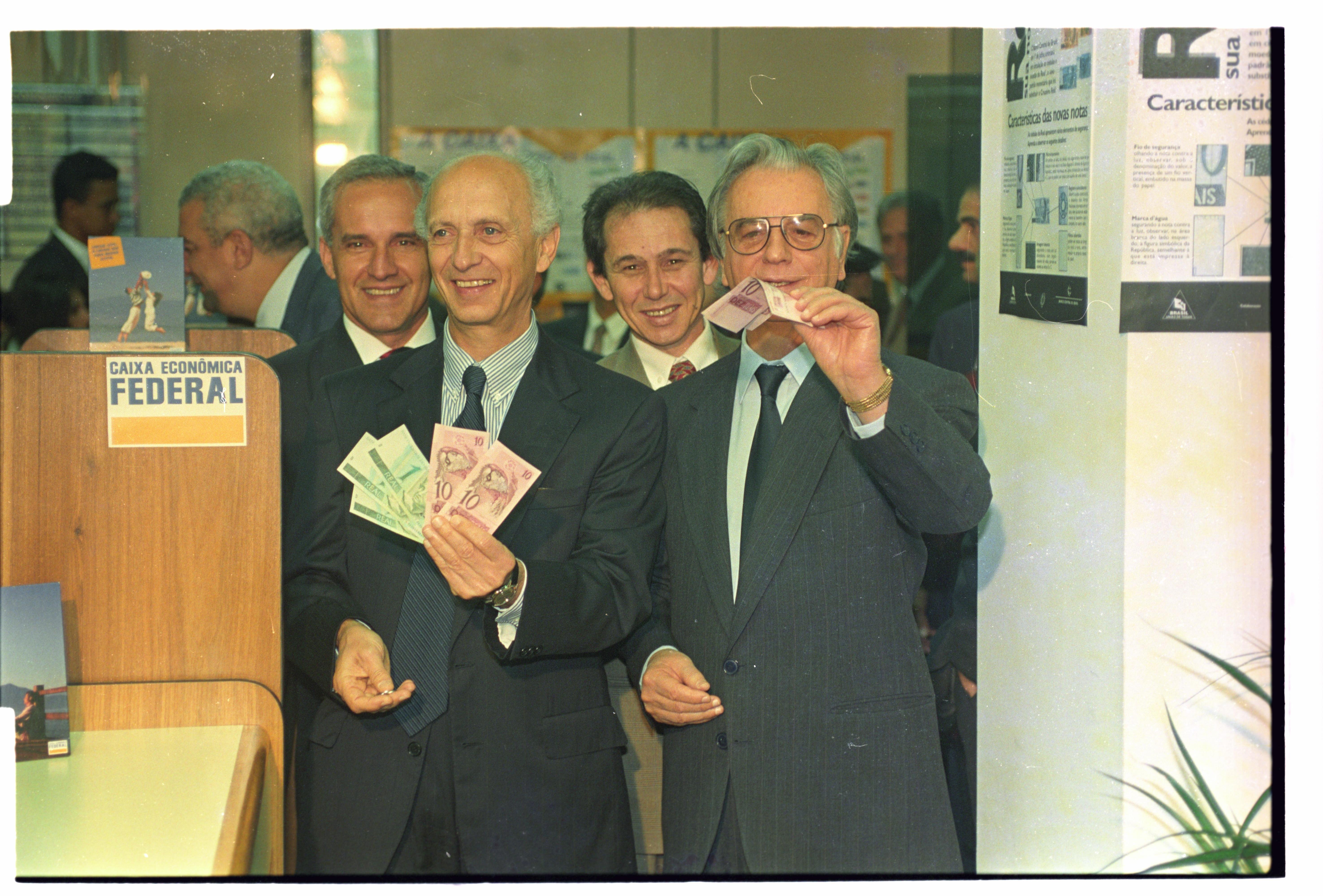 O ex-ministro da Fazenda Rubens Ricupero e o presidente Itamar Franco mostram as cédulas de reais após troca das notas de cruzeiros reais em agência da Caixa no Palácio do Planalto, em Brasília