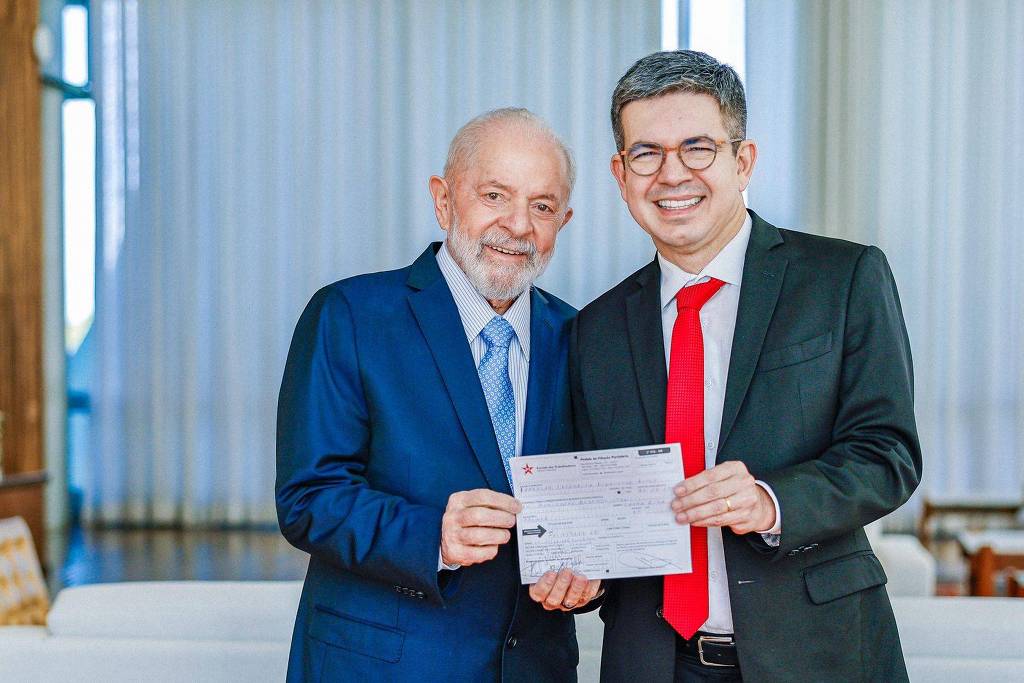 Randolfe Rodrigues mostra a ficha de filiação ao PT ao lado do presidente Lula 