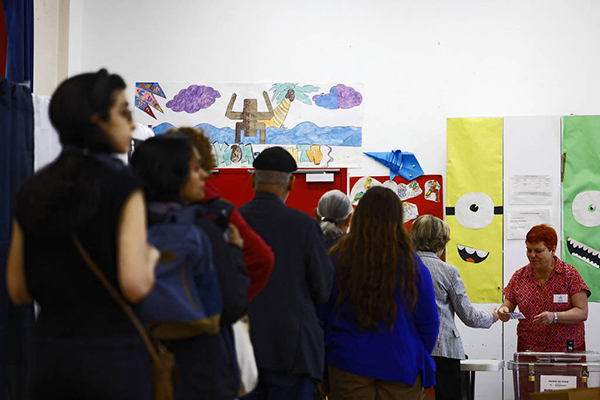 Fila de eleitores em posto de votação de Paris durante o segundo turno das eleições parlamentares na França