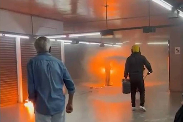 Homem envolto em chamas enquanto funcionários do Metrô usam extintor para apagar as chamas
