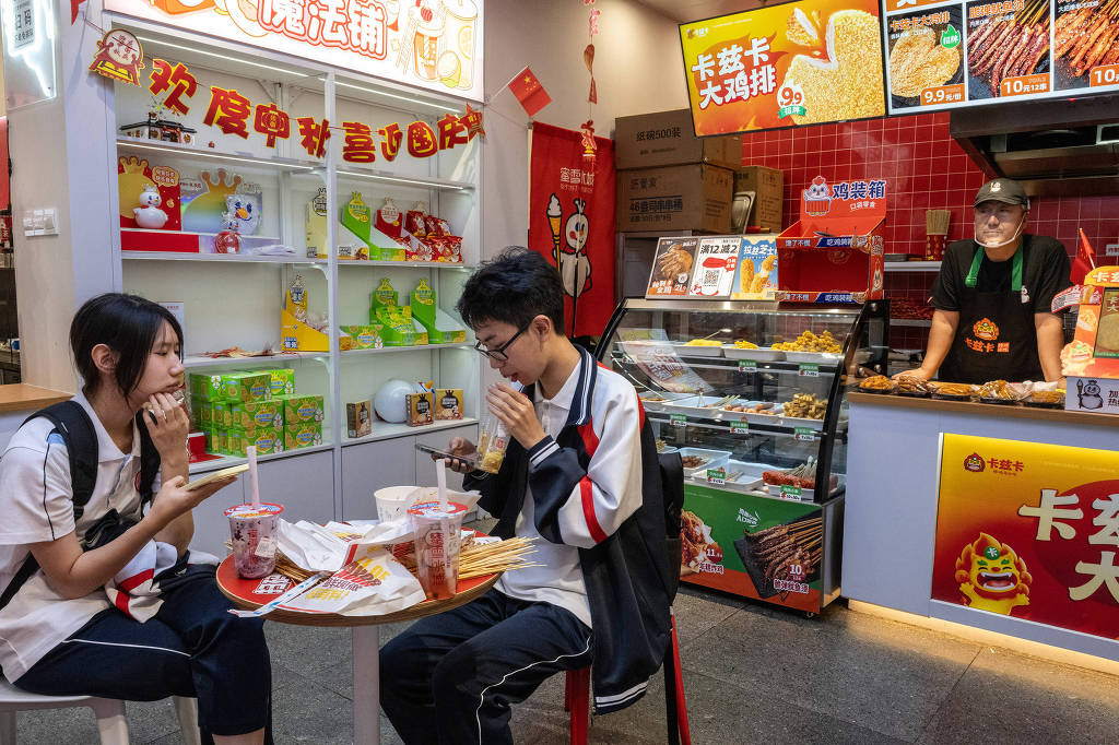 Estudantes em Pequim em uma loja da Mixue, agora a maior rede de fast-food do mundo, que disse que contrataria milhares de pessoas no Brasil e incorporaria ingredientes brasileiros em seus produtos