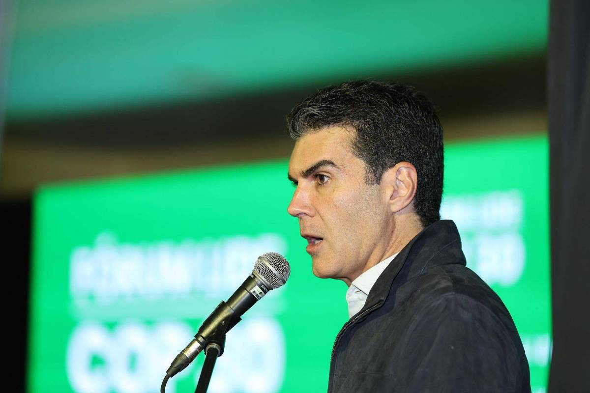 Um homem está falando ao microfone em um evento. Ele usa uma jaqueta escura e uma camisa branca. O fundo é verde com texto em branco, mas o texto não é legível. O homem parece estar concentrado e engajado em sua fala. Um homem está falando ao microfone em um evento. Ele usa uma jaqueta escura e uma camisa branca. O fundo é verde com texto em branco, mas o texto não é legível. O homem parece estar concentrado e engajado em sua fala. O governador do Pará, Helder Barbalho (MDB), durante evento do Lide em Mato Grosso do Sul Um homem está falando ao microfone em um evento. Ele usa uma jaqueta escura e uma camisa branca. O fundo é verde com texto em branco, mas o texto não é legível. O homem parece estar concentrado e engajado em sua fala. Um homem está falando ao microfone em um evento. Ele usa uma jaqueta escura e uma camisa branca. O fundo é verde com texto em branco, mas o texto não é legível. O homem parece estar concentrado e engajado em sua fala. O governador do Pará, Helder Barbalho (MDB), durante evento do Lide em Mato Grosso do Sul